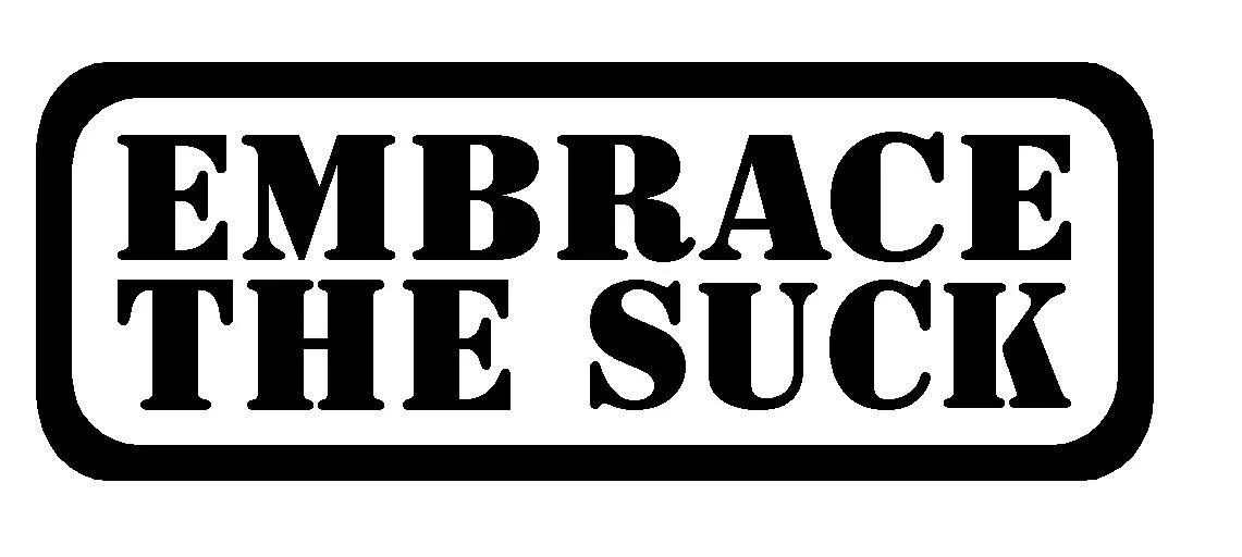 A sign saying 'Embrace the suck'