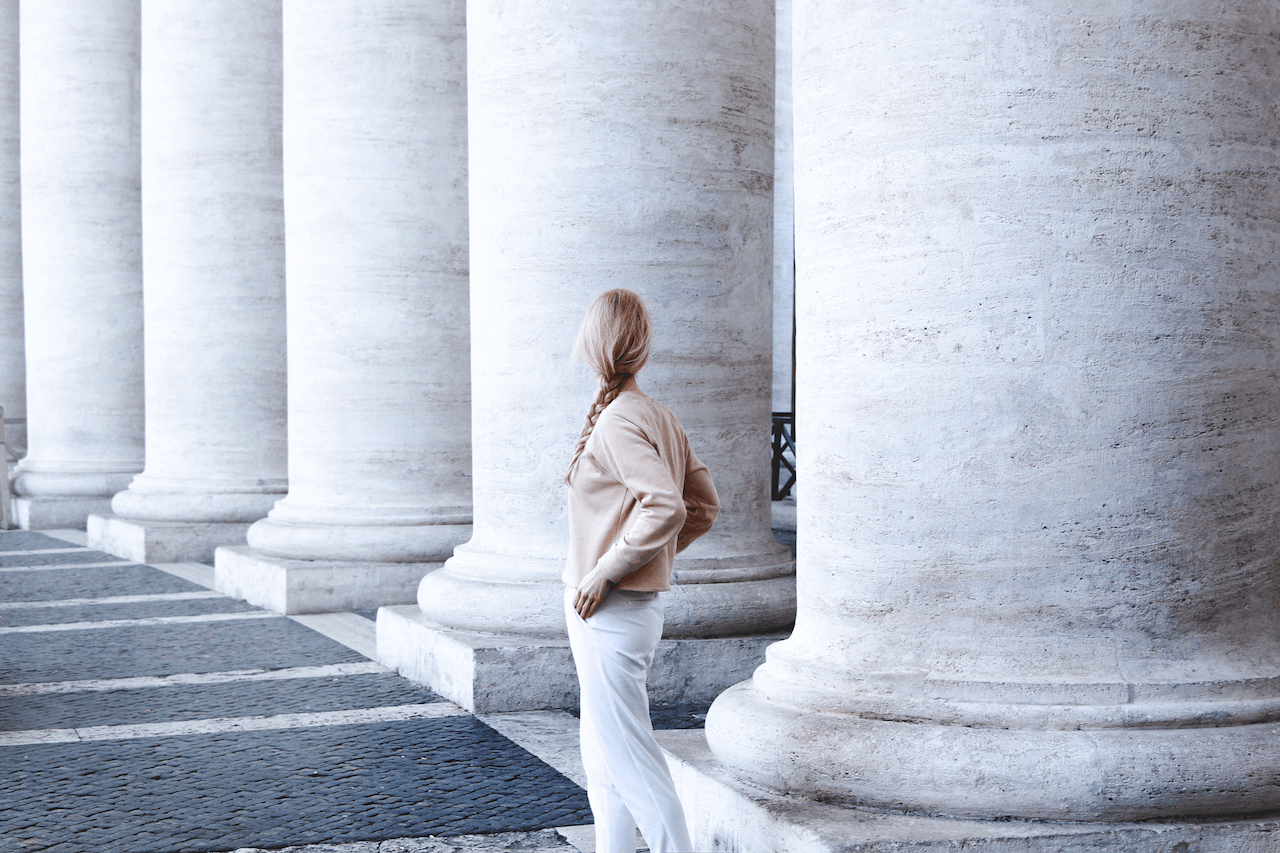 A woman in front of a bunch of pillars